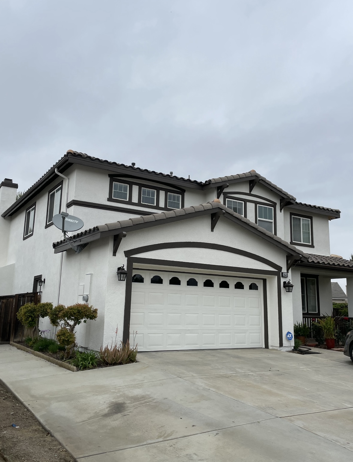 Two-story home repainted white with dark brown trim and fascia